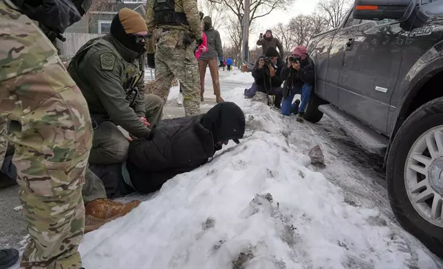 Border Patrol agents detain a man, Sunday, Jan. 11, 2026, in Minneapolis. (AP Photo/Adam Gray)