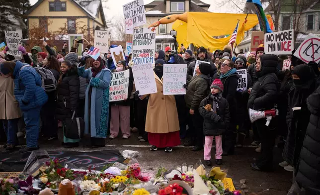 Protesters react as they visit a makeshift memorial during a rally for Renee Good, who was fatally shot by an ICE officer earlier in the week, Saturday, Jan. 10, 2026, in Minneapolis. (AP Photo/John Locher)
