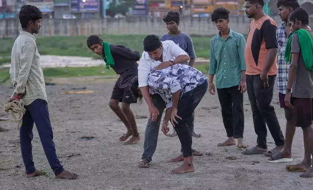 Former champion Manikandan Prabhu, center, trains young men for the Jallikattu bull-taming event at the annual harvest festival called Pongal on the outskirts of Madurai, India, Wednesday, Jan. 14, 2026. (AP Photo/Mahesh Kumar A.)