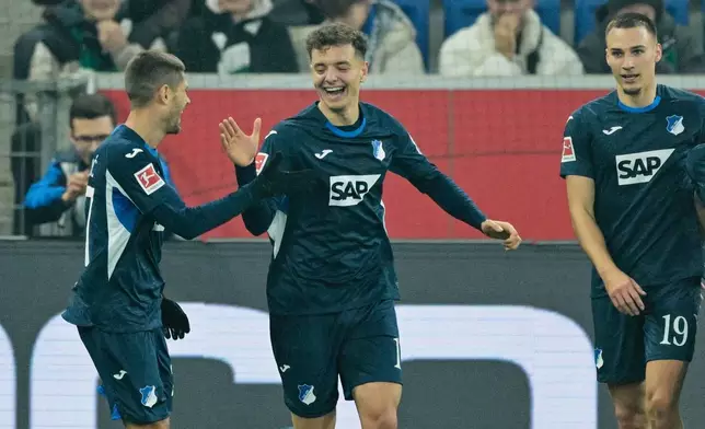 Hoffenheim's Tim Lemperle, center, celebrates scoring during the Bundesliga soccer match between TSG 1899 Hoffenheim and Bor. Mönchengladbach in Sinsheim, Germany, Wednesday Jan. 14, 2026. (Uwe Anspach/dpa via AP)