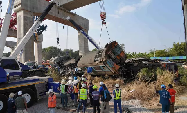 Rescuers try to lift the wreckage after a construction crane fell into a passenger train in Nakhon Ratchasima province, Thailand, Wednesday, Jan.14, 2026. (AP Photo/Sakchai Lalit))