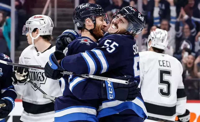 Winnipeg Jets' Mark Scheifele (55) and Gabriel Vilardi, center left, celebrate after Scheifele's goal against the Los Angeles Kings during second-period NHL hockey game action in Winnipeg, Manitoba, Friday, Jan. 9, 2026. (John Woods/The Canadian Press via AP)