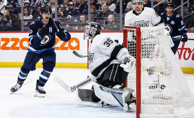 Winnipeg Jets' Mark Scheifele, left, scores against Los Angeles Kings goaltender Darcy Kuemper (35) during second-period NHL hockey game action in Winnipeg, Manitoba, Friday, Jan. 9, 2026. (John Woods/The Canadian Press via AP)