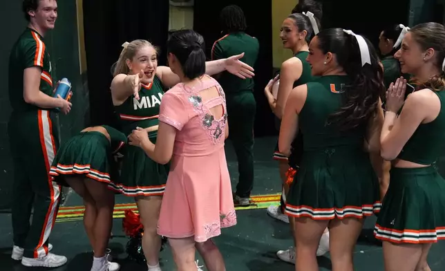 Miami cheerleaders react as they meet Red Panda after she performed at halftime of an NCAA college basketball game between Miami and Stanford in Coral Gables, Fla., Wednesday, Jan. 28, 2026. (AP Photo/Rebecca Blackwell)