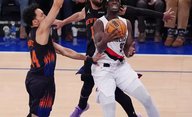 Portland Trail Blazers' Sidy Cissoko, right, drives past New York Knicks' Jalen Brunson and Landry Shamet, left, during the second half of an NBA basketball game Friday, Jan. 30, 2026, in New York. (AP Photo/Frank Franklin II)