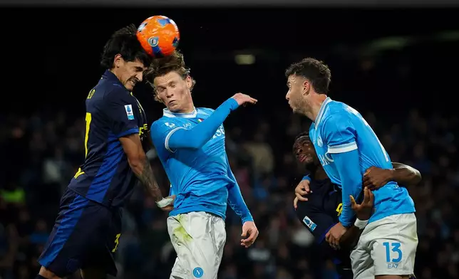 Napoli's Scott McTominay, center, and Parma's Mariano Troilo, left, in action during the Serie A soccer match between Napoli and Parma, in Naples, Italy, Wednesday, Jan. 14, 2026. (Alessandro Garofalo/LaPresse via AP)
