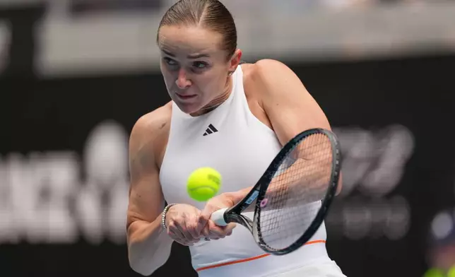Elina Svitolina of Ukraine plays a backhand return to Linda Klimovicova of Poland during their second round match at the Australian Open tennis championship in Melbourne, Australia, Wednesday, Jan. 21, 2026. (AP Photo/Aaron Favila)