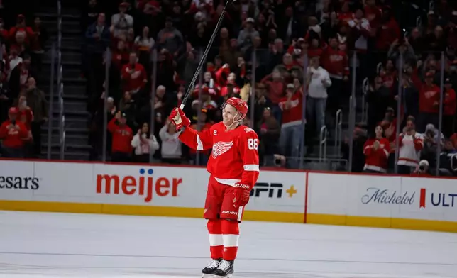 Detroit Red Wings right wing Patrick Kane acknowleges the fans after recording his 1,375th point to pass Mike Modano and break the NHL record for points by a player born in the United States, during the second period of an NHL hockey game Thursday, Jan. 29, 2026, in Detroit. Kane assisted on a goal by defenseman Ben Chiarot to break the record. (AP Photo/Duane Burleson)