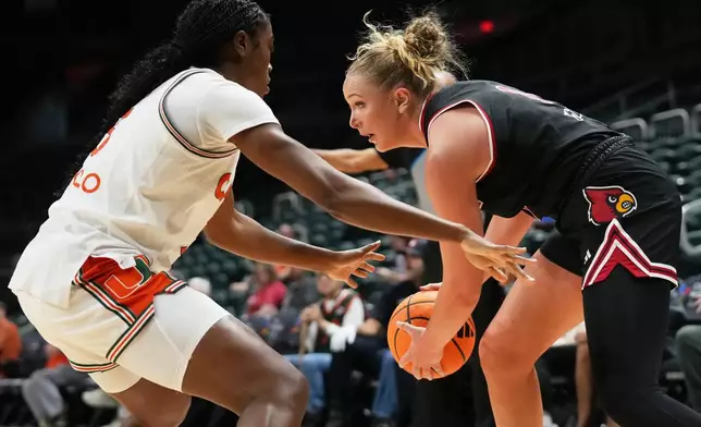 Louisville forward Laura Ziegler, right, controls the ball as Miami forward Soma Okolo, left, defends during the first half of an NCAA college basketball game, Thursday, Jan. 8, 2026, in Coral Gables, Fla. (AP Photo/Lynne Sladky)