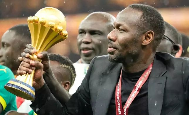 Senegal's head coach Pape Thiaw holds the trophy after winning the Africa Cup of Nations final soccer match agaisnt Morocco, in Rabat, Morocco, Sunday, Jan. 18, 2026. (AP Photo/Mosa'ab Elshamy)