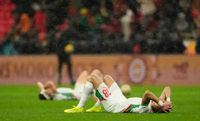 Moroccan players lie after losing the Africa Cup of Nations final soccer match between Senegal and Morocco, in Rabat, Morocco, Sunday, Jan. 18, 2026. (AP Photo/Mosa'ab Elshamy)