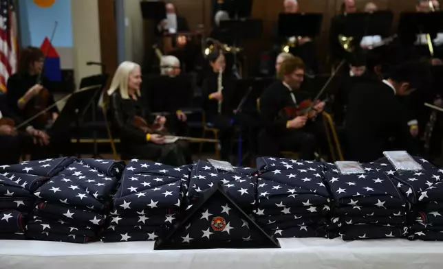 Flags in honor of fire victims are placed on a table on the one-year anniversary of the Palisades Fire in the Pacific Palisades neighborhood of Los Angeles Wednesday, Jan. 7, 2026. (AP Photo/Jae C. Hong)