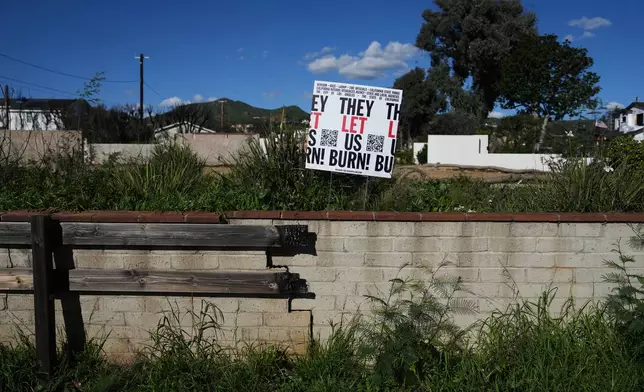 A sign is placed on a fire-damaged property on the one-year anniversary of the Palisades Fire in the Pacific Palisades neighborhood of Los Angeles Wednesday, Jan. 7, 2026. (AP Photo/Jae C. Hong)