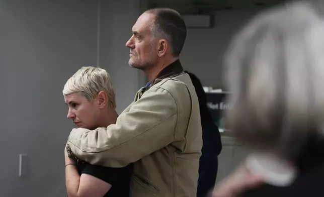 Eleanor Godfrey, left, is hugged by her husband Seth Morris during a gathering of survivors on the one-year anniversary of the Eaton Fire Wednesday, Jan. 7, 2026, in Altadena, Calif. (AP Photo/Gregory Bull)
