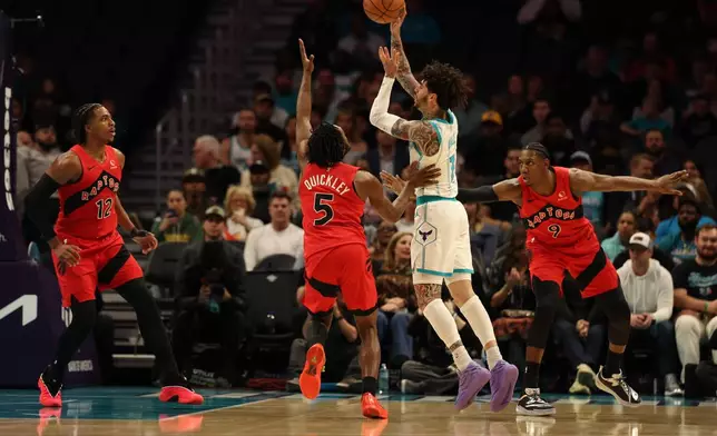 Charlotte Hornets guard Lamelo Ball (1) shoots the ball against Toronto Raptors guard Immanuel Quickley (5), Toronto Raptors forward Collin Murray-Boyles (12) , left, and Toronto Raptors forward/guard RJ Barrett (9), right, during the first half of an NBA basketball game on Wednesday, Jan. 7, 2026, in Charlotte, N.C. (AP Photo/Krista Jasso)