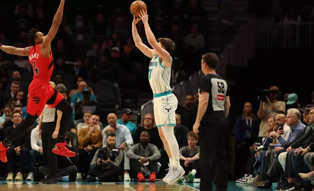 Charlotte Hornets guard/forward Kon Knueppel (7) shoots the ball against Toronto Raptors forward/guard Scottie Barnes (4) during the first half of an NBA basketball game on Wednesday, Jan. 7, 2026, in Charlotte, N.C. (AP Photo/Krista Jasso)
