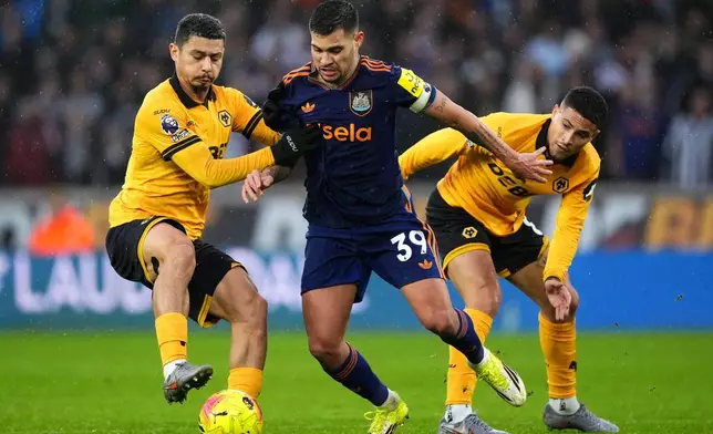 Wolverhampton Wanderers' Andre, left, and Joao Gomes challenge Newcastle United's Bruno Guimaraes during the English Premier League soccer match between Wolves and Newcastle United in Wolverhampton, England, Sunday Jan. 18, 2026. (Mike Egerton/PA via AP)