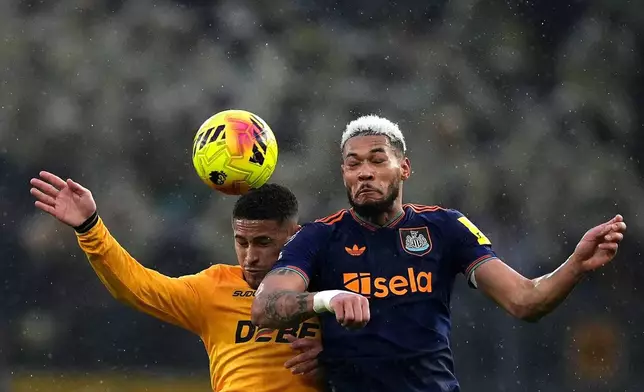 Wolverhampton Wanderers' Joao Gomes, left, and Newcastle United's Joelinton battle for the ball during the English Premier League soccer match between Wolves and Newcastle United in Wolverhampton, England, Sunday Jan. 18, 2026. (Martin Rickett/PA via AP)