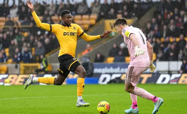 Wolverhampton Wanderers' Yerson Mosquera, left, and Newcastle United goalkeeper Nick Pope in action during the English Premier League soccer match between Wolves and Newcastle United in Wolverhampton, England, Sunday Jan. 18, 2026. (Martin Rickett/PA via AP)