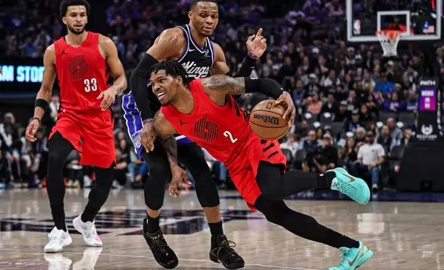 Portland Trail Blazers guard Caleb Love (2) dribbles past Sacramento Kings guard Russell Westbrook, back, during the first half of an NBA basketball game, Sunday, Jan. 18, 2026, in Sacramento, Calif. (AP Photo/Justine Willard)