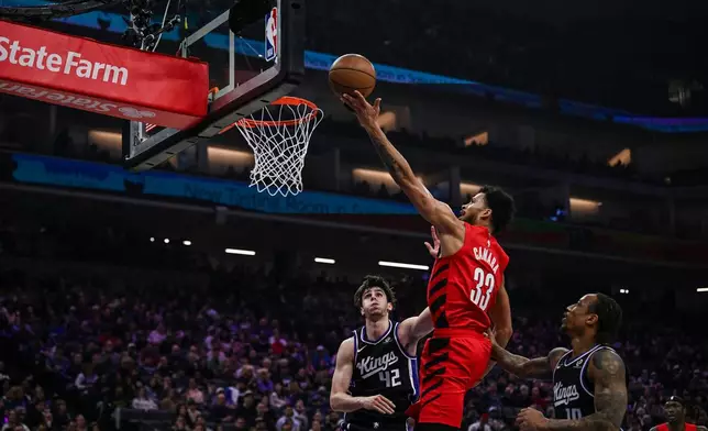 Portland Trail Blazers forward Toumani Camara (33) goes for a layup against Sacramento Kings center Maxime Raynaud (42) during the first half of an NBA basketball game, Sunday, Jan. 18, 2026, in Sacramento, Calif. (AP Photo/Justine Willard)