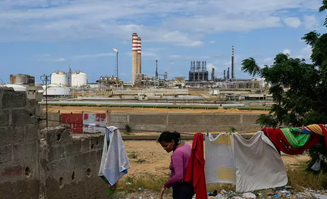 A woman who lives near the Cardon refinery hangs clothes to dry in Punto Fijo, Venezuela, Wednesday, Jan. 14, 2026. (AP Photo/Matias Delacroix)