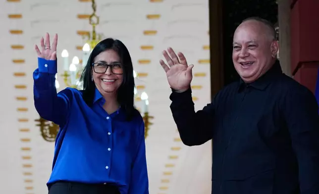 Venezuela's acting President Delcy Rodriguez and Interior Minister Diosdado Cabello, right, wave before making a statement at Miraflores presidential palace in Caracas, Venezuela, Wednesday, Jan. 14, 2026. (AP Photo/Ariana Cubillos)