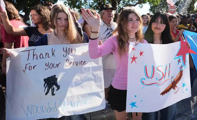 Students from the Coral Shores High School wave as wounded veterans ride past in the annual Florida Keys Soldier Ride organized by the Wounded Warrior Project, Friday, Jan. 9, 2026, in Islamorada, Fla. (AP Photo/Lynne Sladky)