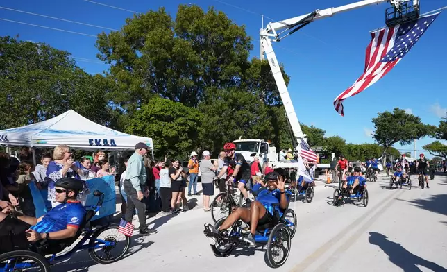 Wounded veterans ride past a crowd gathered at Coral Shores High School in the annual Florida Keys Soldier Ride organized by the Wounded Warrior Project, Friday, Jan. 9, 2026, in Islamorada, Fla. (AP Photo/Lynne Sladky)