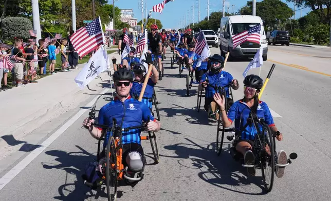 People line the street as wounded veterans ride in the annual Florida Keys Soldier Ride organized by the Wounded Warrior Project, Friday, Jan. 9, 2026, in Marathon, Fla. (AP Photo/Lynne Sladky)