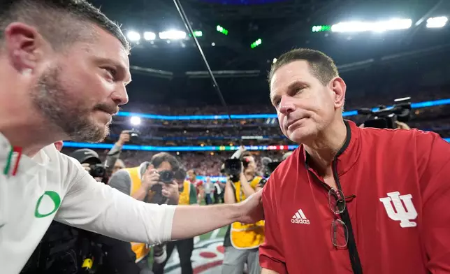 Oregon head coach Dan Lanning, left, greets Indiana head coach Curt Cignetti after the Peach Bowl NCAA college football playoff semifinal, Friday, Jan. 9, 2026, in Atlanta. (AP Photo/Brynn Anderson)