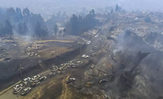 FILE - Damaged vehicles line a road after wildfires swept through residential areas in Lirquen, Chile, Jan. 18, 2026. (AP Photo/Javier Torres, File)