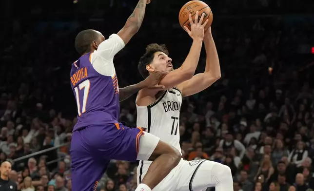 Brooklyn Nets forward Michael Porter Jr. drives on Phoenix Suns guard Jamaree Bouyea (17) during the first half of an NBA basketball game, Tuesday, Jan. 27, 2026, in Phoenix. (AP Photo/Rick Scuteri)