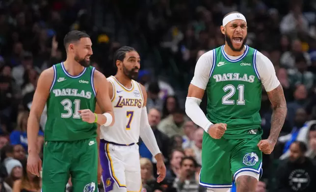Dallas Mavericks forward Daniel Gafford (21) reacts after scoring a basket as teammate guard Klay Thompson (31) and Los Angeles Lakers guard Gabe Vincent (7) look on during the second half of an NBA basketball game Saturday, Jan. 24, 2026, in Dallas. (AP Photo/Julio Cortez)