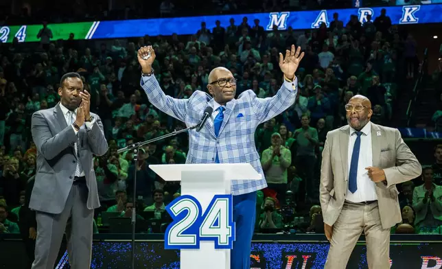 Former Dallas Mavericks player Mark Aguirre, center, reacts during his jersey retirement presentation at halftime during an NBA basketball game between the Mavericks and the Charlotte Hornets, Thursday, Jan. 29, 2026, in Dallas. (AP Photo/Jessica Tobias)