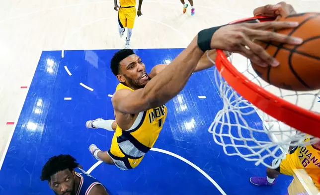 Indiana Pacers' Tony Bradley, center, dunks as Philadelphia 76ers' Joel Embiid, left, watches during the first half of an NBA basketball game, Monday, Jan. 19, 2026, in Philadelphia. (AP Photo/Chris Szagola)