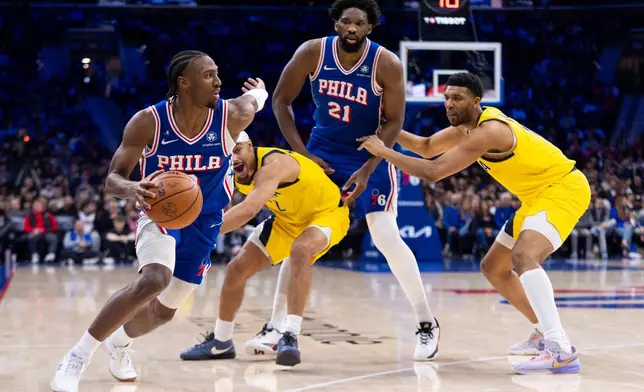 Philadelphia 76ers' Tyrese Maxey, left, uses Joel Embiid (21) as a screen against Indiana Pacers' Andrew Nembhard, center left, as he makes his way to the basket during the first half of an NBA basketball game, Monday, Jan. 19, 2026, in Philadelphia. (AP Photo/Chris Szagola)