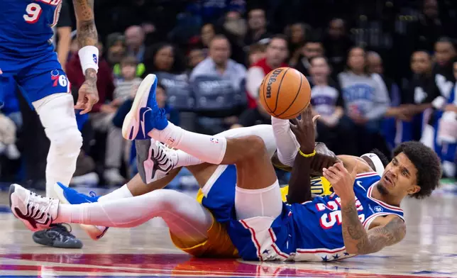 Philadelphia 76ers' Dom Barlow, front right, passes the ball that he took away from Indiana Pacers' Pascal Siakam, back right, while on the floor during the first half of an NBA basketball game, Monday, Jan. 19, 2026, in Philadelphia. (AP Photo/Chris Szagola)