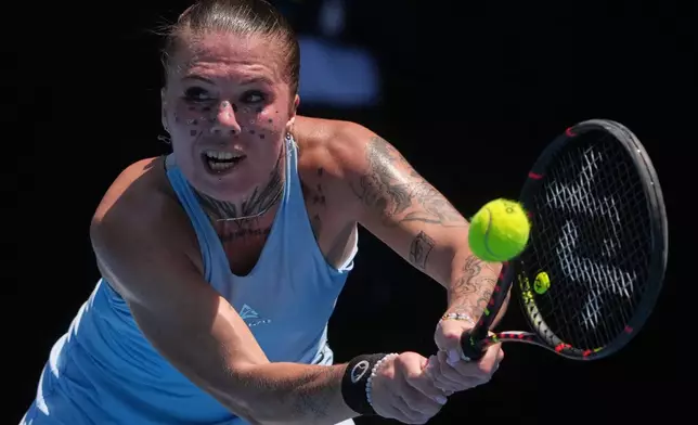 Oleksandra Oliynykova of Ukraine plays a backhand return to Madison Keys of the U.S. during their first round match at the Australian Open tennis championship in Melbourne, Australia, Tuesday, Jan. 20, 2026. (AP Photo/Asanka Brendon Ratnayake)