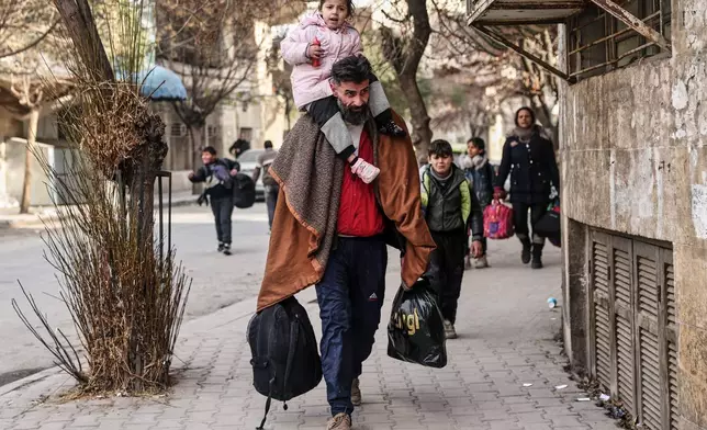 Residents flee the Sheikh Maqsoud and Achrafieh neighbourhoods after clashes erupted Tuesday between Syrian government forces and Kurdish fighters in a contested area of the northern city of Aleppo, Syria, Thursday, Jan. 8, 2026. (AP Photo/Ghaith Alsayed)