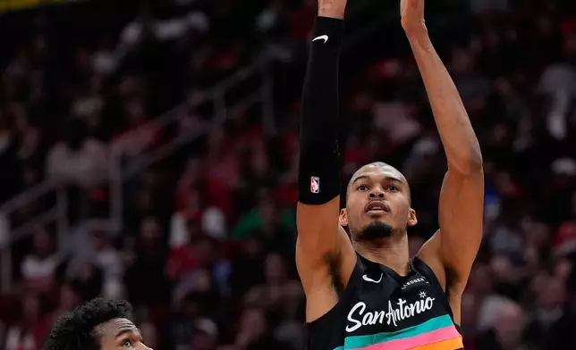 San Antonio Spurs forward Victor Wembanyama (1) shoots against Houston Rockets forward Tari Eason (17) during the first half of an NBA basketball game in Houston, Tuesday, Jan. 20, 2026. (AP Photo/Ashley Landis)