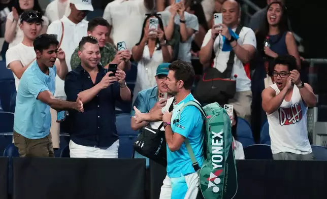 Stan Wawrinka of Switzerland gestures with fans as he walks onto court for his third round match against Taylor Fritz of the U.S. at the Australian Open tennis championship in Melbourne, Australia, Saturday, Jan. 24, 2026. (AP Photo/Asanka Brendon Ratnayake)