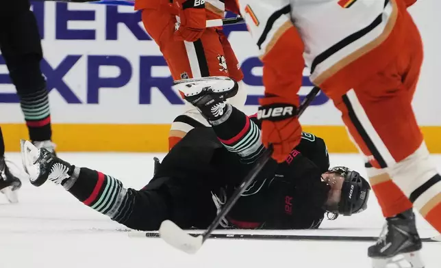 Seattle Kraken left wing Jared McCann falls after getting hit by the puck against the Anaheim Ducks during the first period of an NHL hockey game Friday, Jan. 23, 2026, in Seattle. (AP Photo/Lindsey Wasson)
