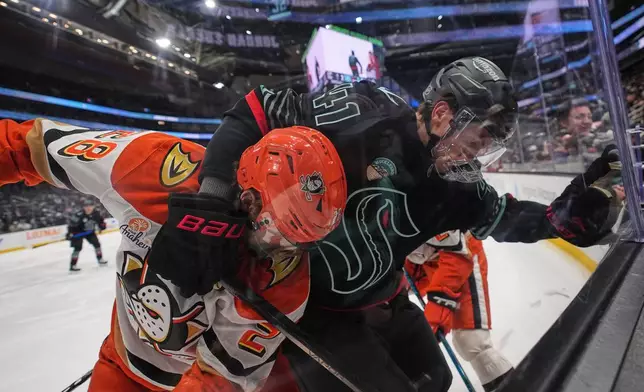 Anaheim Ducks left wing Jeffrey Viel, left, vies for the puck against Seattle Kraken defenseman Ryker Evans, right, against the boards during the second period of an NHL hockey game Friday, Jan. 23, 2026, in Seattle. (AP Photo/Lindsey Wasson)