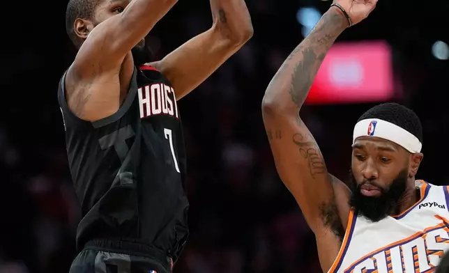 Houston Rockets' Kevin Durant (7) shoots a game-winning 3-pointer as Phoenix Suns' Royce O'Neale defends during the second half of an NBA basketball game Monday, Jan. 5, 2026, in Houston. (AP Photo/David J. Phillip)