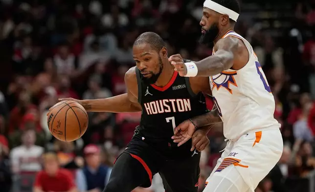 Houston Rockets' Kevin Durant (7) is defended by Phoenix Suns' Royce O'Neale during the second half of an NBA basketball game Monday, Jan. 5, 2026, in Houston. (AP Photo/David J. Phillip)