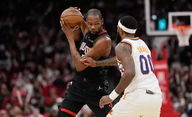 Houston Rockets' Kevin Durant, left, is defended by Phoenix Suns' Royce O'Neale (00) during the second half of an NBA basketball game Monday, Jan. 5, 2026, in Houston. (AP Photo/David J. Phillip)
