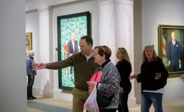People react to a photograph of President Donald Trump on display at the Smithsonian's National Portrait Gallery's "American Presidents" exhibit on Sunday, Jan. 11, 2026 in Washington. (AP Photo/Rod Lamkey, Jr.)