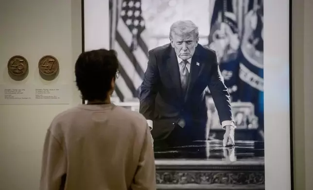 Visitors stop to look at a photograph of President Donald Trump and a short plaque next to it are on display at the Smithsonian's National Portrait Gallery's "American Presidents" exhibit on Sunday, Jan. 11, 2026 in Washington. (AP Photo/Rod Lamkey, Jr.)