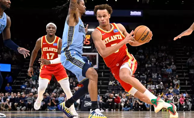 Atlanta Hawks guard Dyson Daniels (5) drives against Memphis Grizzlies guard Ja Morant (12) in the first half of an NBA basketball game Wednesday, Jan. 21, 2026, in Memphis, Tenn. (AP Photo/Brandon Dill)